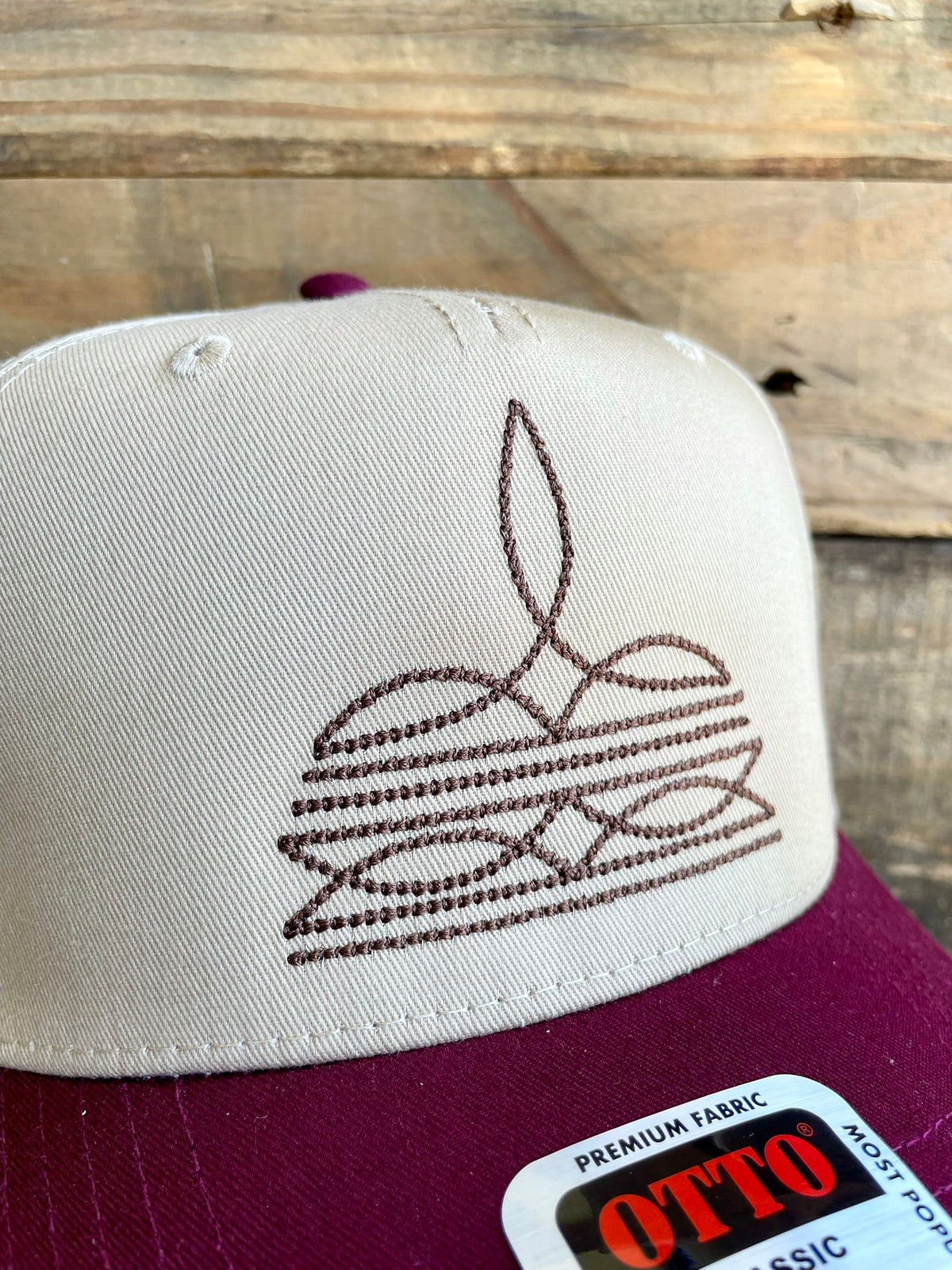 Cap with embroidered design on a wooden surface, featuring the Otto brand label.